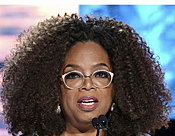 Woman with curly hair and glasses at microphone