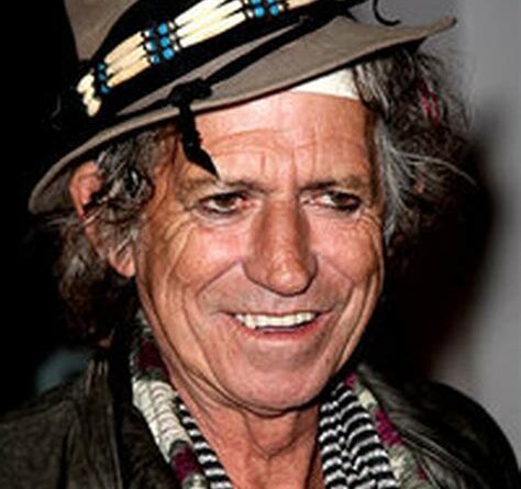 Smiling man wearing hat and patterned scarf
