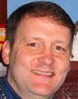 Smiling man with short brown hair