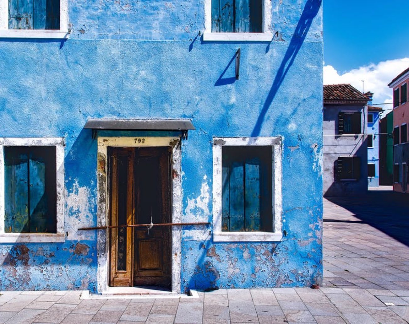 Weathered blue house facade with wooden door