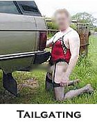 Person in red and black lingerie kneeling beside a vehicle outdoors.