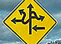 road sign with f roads all pointing in different directions