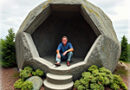 an image of a man sitting in a hollowed out large boulder