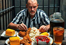 A prisoner in his cell eating his last meal.