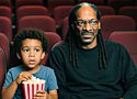 Snoop Dogg and his grandson sitting in a movie theater watching Lightyear, a movie with an LGBTQ undertone.